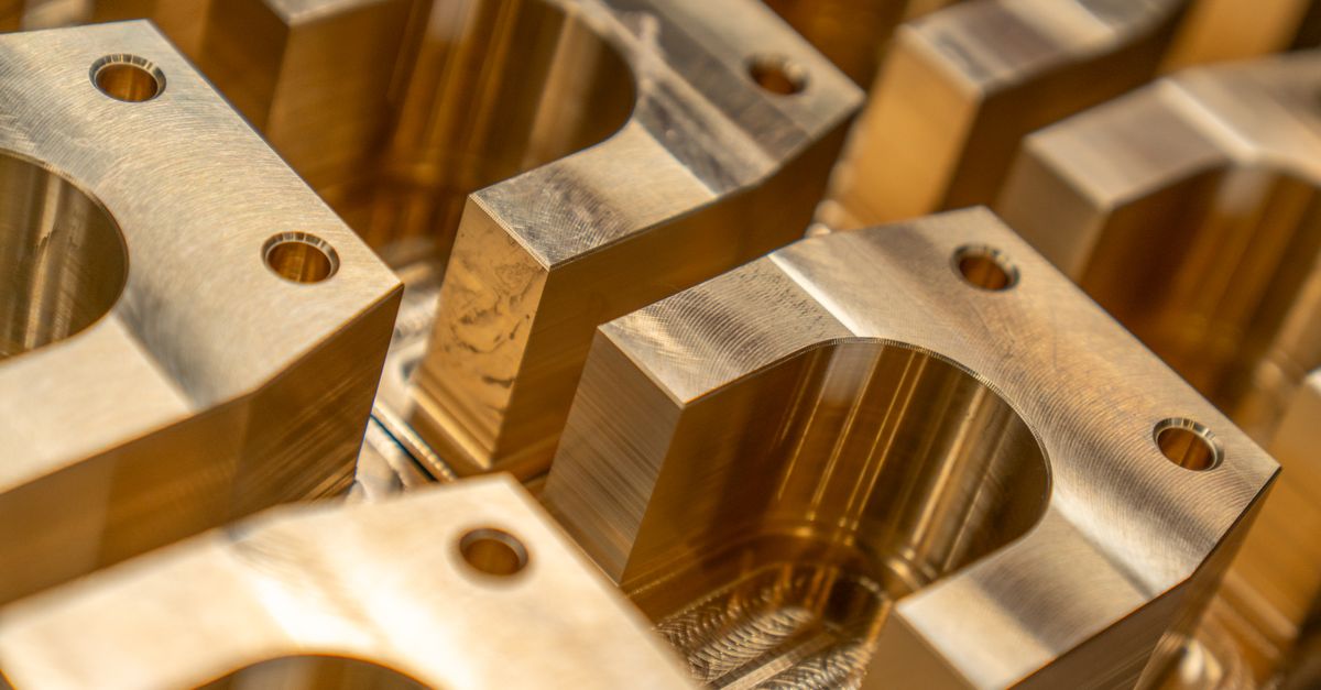 Auto parts packing problem: bright machined metal brackets with bolt holes sitting side by side, unwrapped